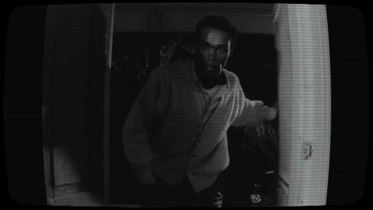 Dark black and white photo with a man in white, in the shadows