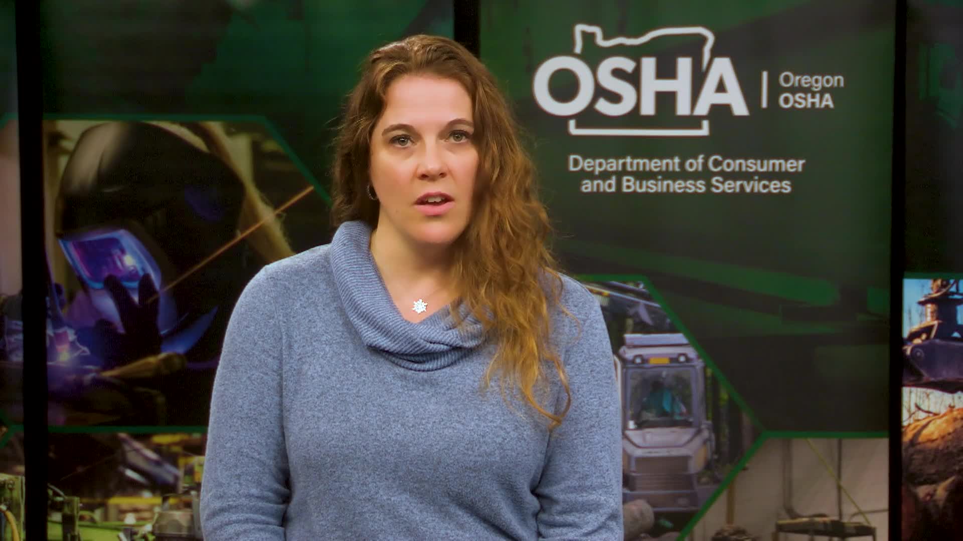 Woman in blue standing in the middle with a OSHA poster in the background in green.