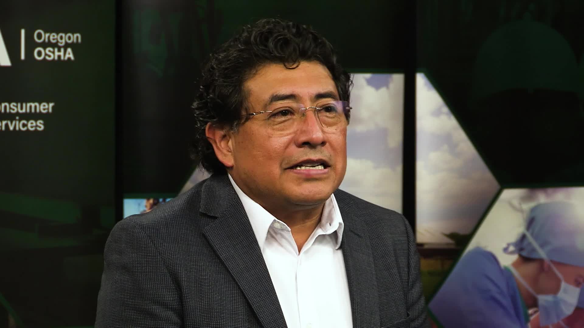 Hispanic man in a suit sitting looking off camera
