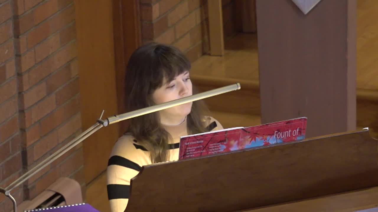 Woman seated behind a piano.