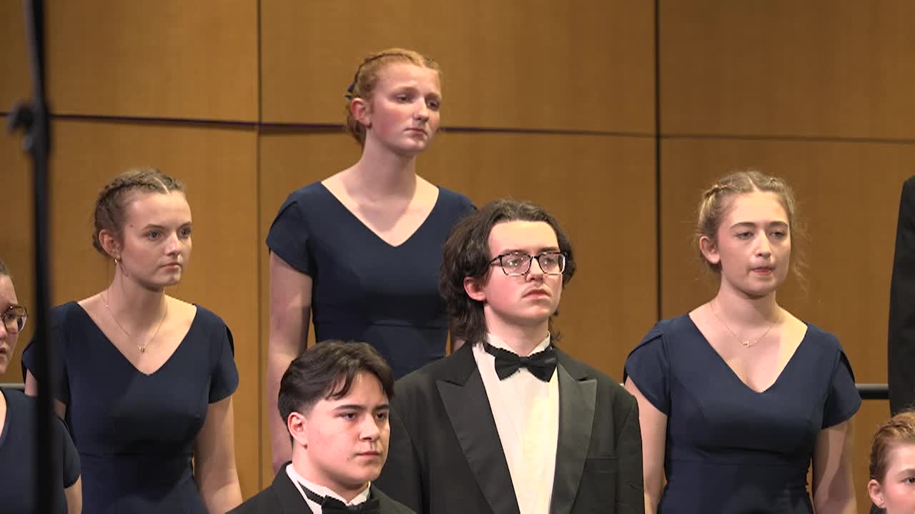 Boys and girls dressed in fancy black clothes on choir risers