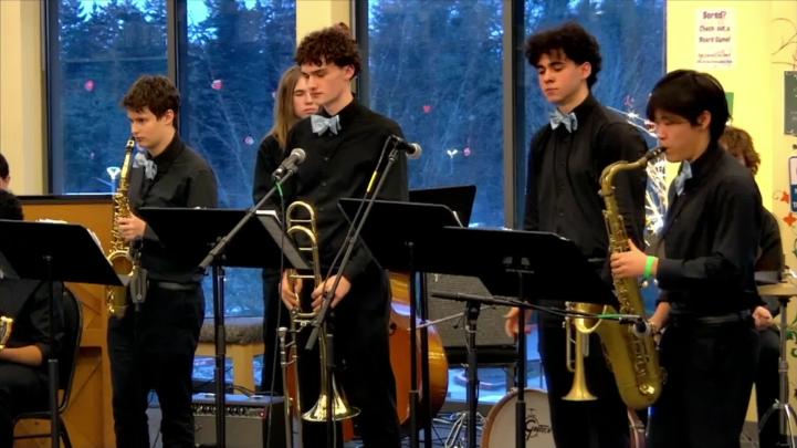 Kids wearing black standing with musical instruments