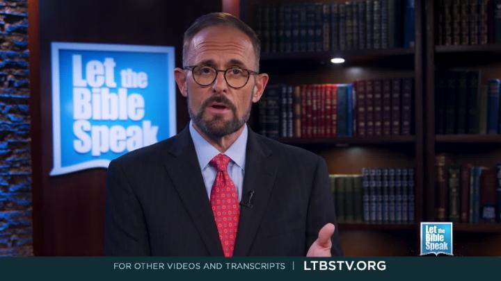 Man in a suit and glasses. Bookshelf back right. Blue and white "Let the Bible Speak"logo back left.