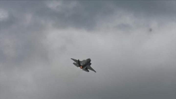 Military fighter jet flying in a clouded sky