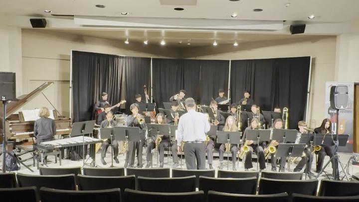 Students on a stage playing musical instruments