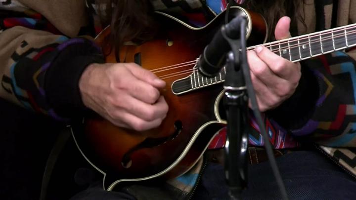 close up of a brown guitar being played