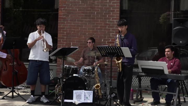 Brick building background. Jazz musicians in the front