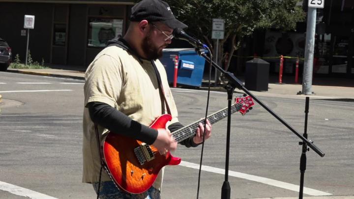Man playing guitar on a street corner 