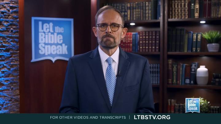 Man in a blue suit and glasses standing. Bookshelf in the background. Blue "Let The Bible Speak" logo to the back left