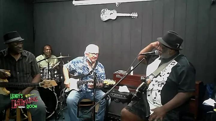 grey wall in back. Musicians on stage.