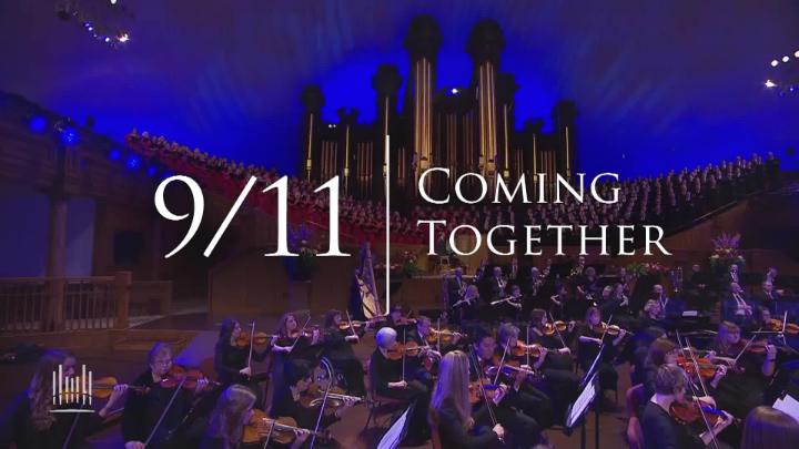 Blue and purple lights in the back with a large choir of people. White words in the center: 