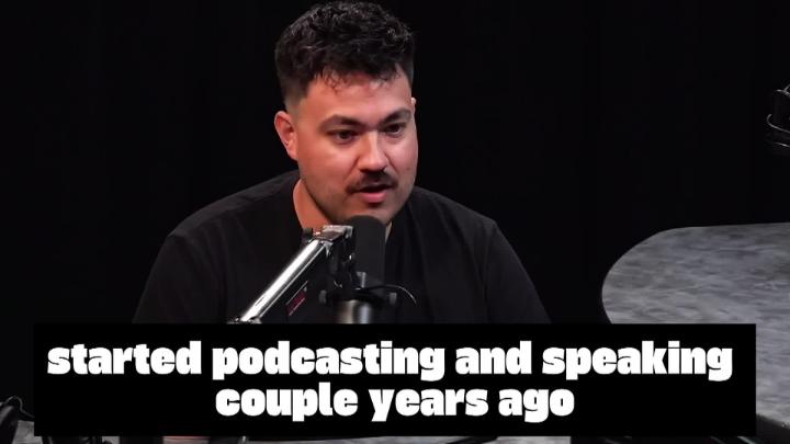 Man dressed in black behind a podcast mic. White words at the bottom: "started podcasting and speaking couple years ago"