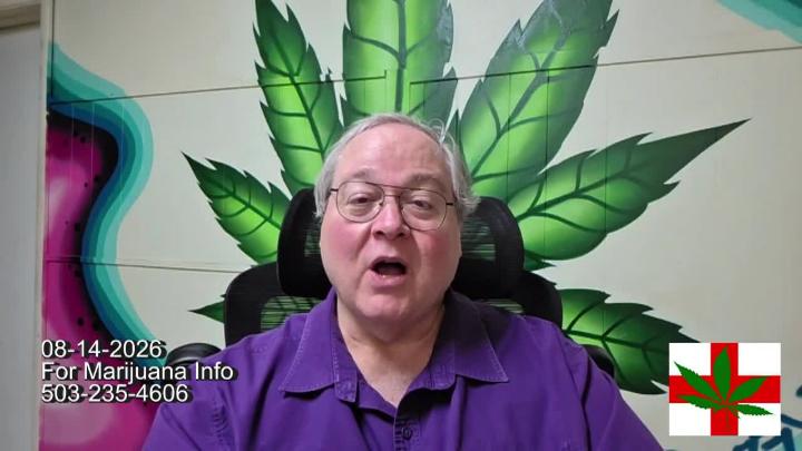 Older man in glasses and a purple shirt seated in front of a brick wall with a large green cannabis leaf on it.
