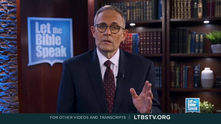 Man in a blue suit standing in the center. Book shelf in the background. Blue Let the Bible Speak logo in the bottom right corner and back left.