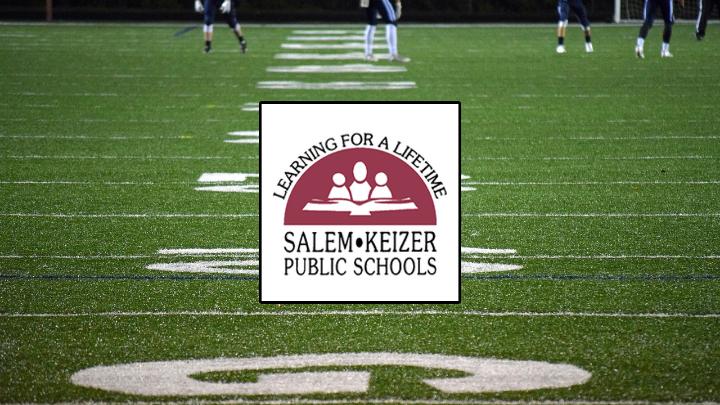 football field with white and maroon Salem Keizer Public Schools logo in the center