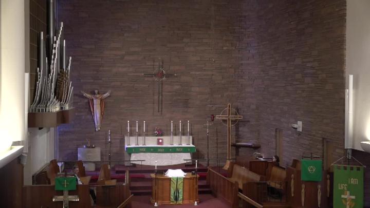 Brick background with an alter in the middle and a statue of Jesus to the left.