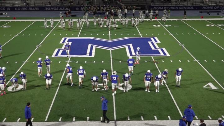 Football field with players in blue and white uniforms