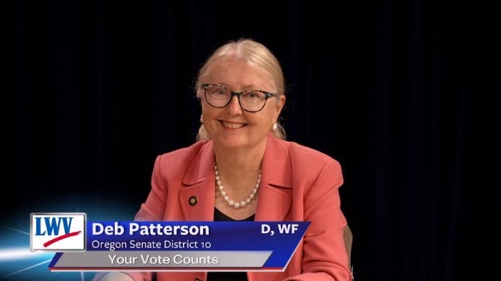 Black background. woman in a coral blazer in the middle. Lower thirds to the bottom left with red, white and blue LWV logo. White words on a blue background: Deb Patterson Oregon Senate District 10 Your Vote Counts D, WF