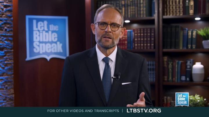 Man in a dark suit and glasses in the center. Bookshelf in the background. Blue and white Let The Bible Speak logo back left