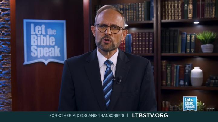 man in a blue suit standing in the center. Bookshelf to the back right. Blue "Let the Bible Speak" logo in the back left