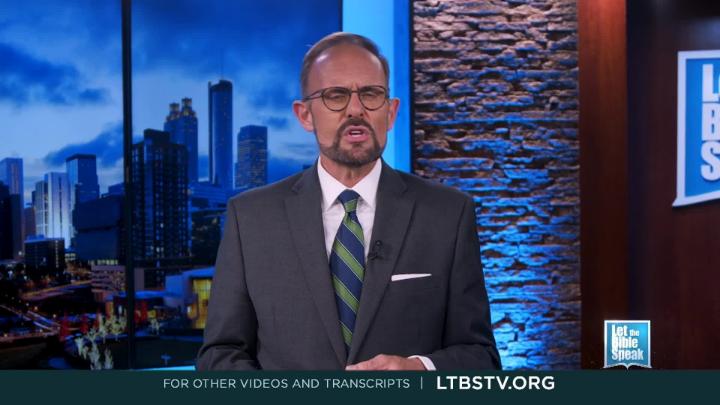 Man standing in the middle wearing a suit. Cityscape picture in the background