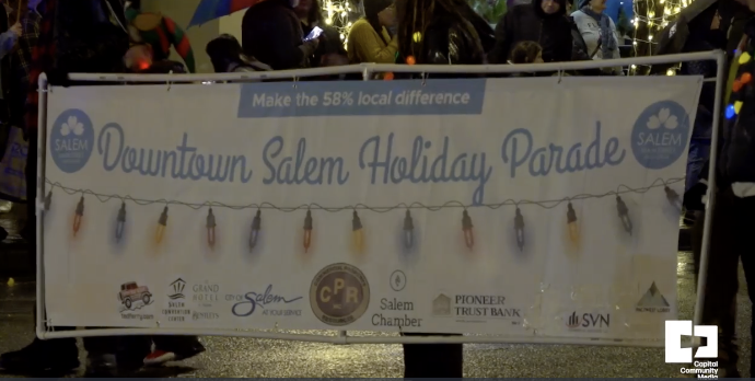 Banner with "Downtown Salem Holiday Parade" in blue with Christmas light printed underneath the words. City of Salem logo, Tedd Ferry Insurance logo in red, Salem Chamber logo along the bottom 