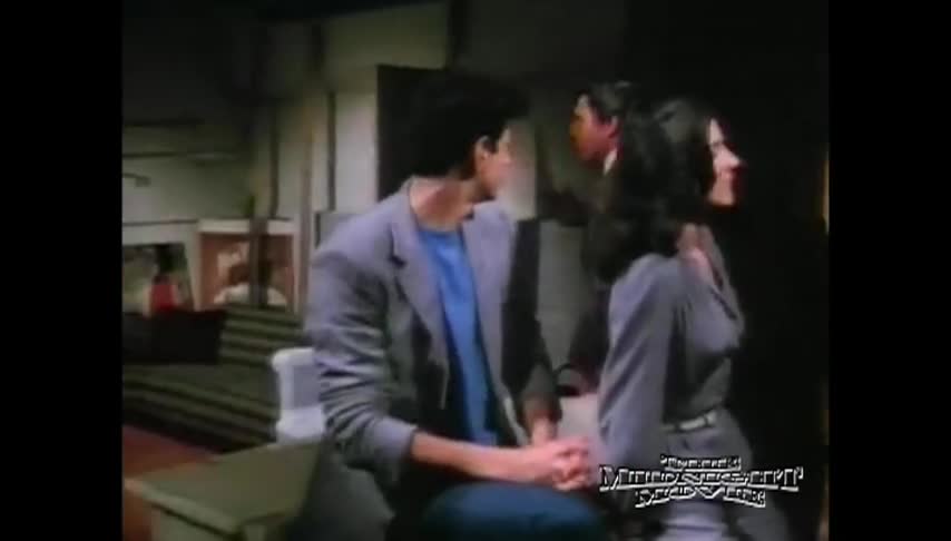 Man and woman dressed in grey looking away from the camera in the center